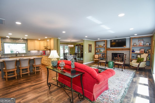 living room featuring ornamental molding, a brick fireplace, a wealth of natural light, and dark hardwood / wood-style flooring