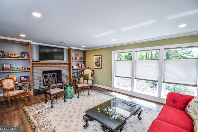 living room with wood-type flooring, a fireplace, and ornamental molding