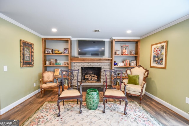 sitting room featuring a fireplace, crown molding, and hardwood / wood-style floors