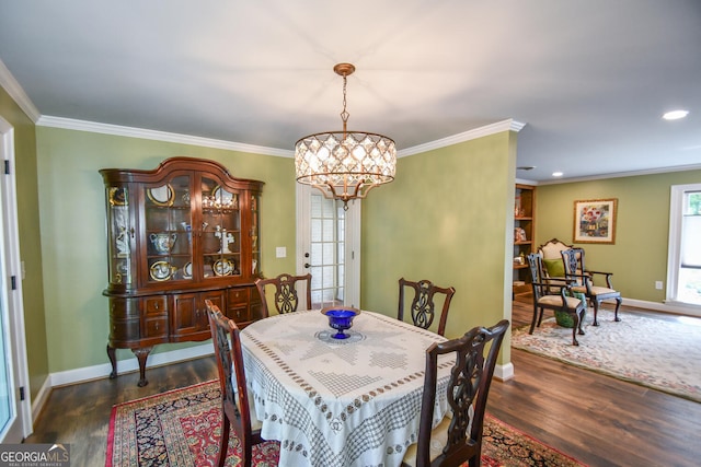 dining space with ornamental molding, a chandelier, and dark hardwood / wood-style flooring