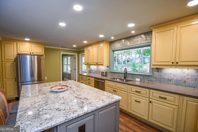 kitchen featuring a kitchen island, dark hardwood / wood-style floors, sink, dark stone counters, and appliances with stainless steel finishes