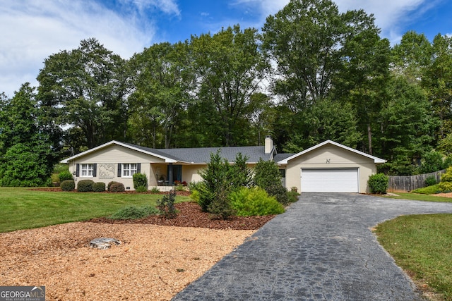 ranch-style house featuring a garage and a front lawn