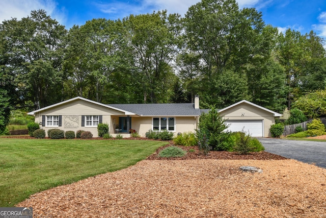 ranch-style home with a garage, an outdoor structure, and a front lawn