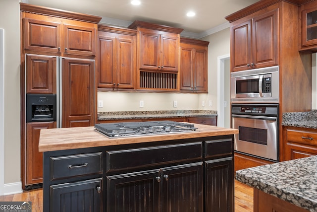 kitchen with light hardwood / wood-style floors, wood counters, crown molding, and stainless steel appliances