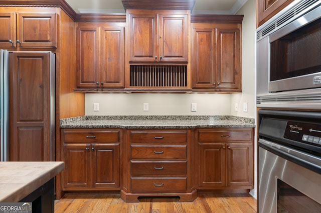 kitchen with built in appliances, light hardwood / wood-style floors, and crown molding