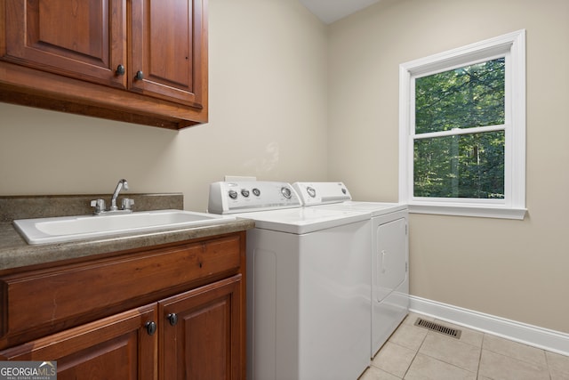 laundry area featuring sink, cabinets, washing machine and clothes dryer, and light tile patterned flooring