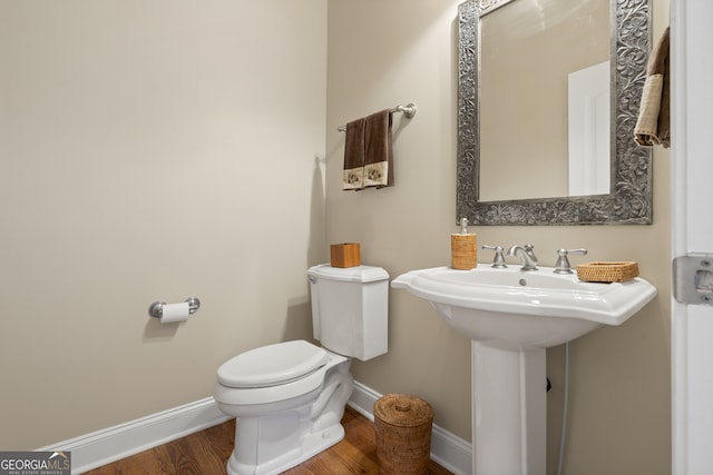 bathroom featuring hardwood / wood-style flooring and toilet