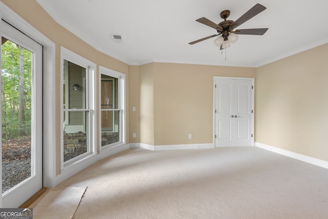 spare room featuring ornamental molding, light carpet, and ceiling fan