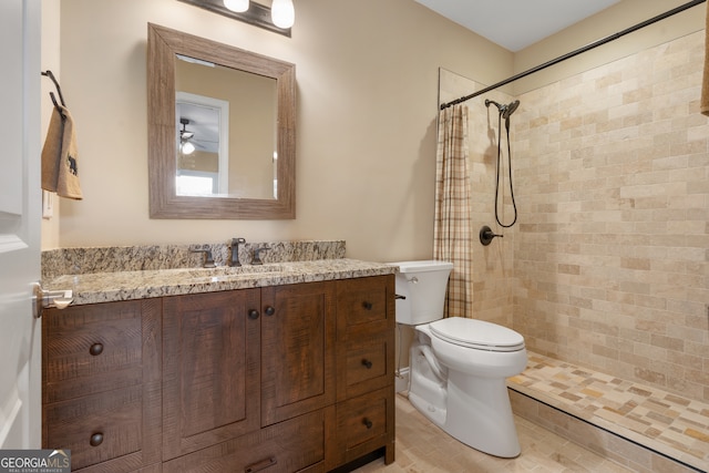 bathroom with a shower with curtain, vanity, hardwood / wood-style flooring, toilet, and ceiling fan