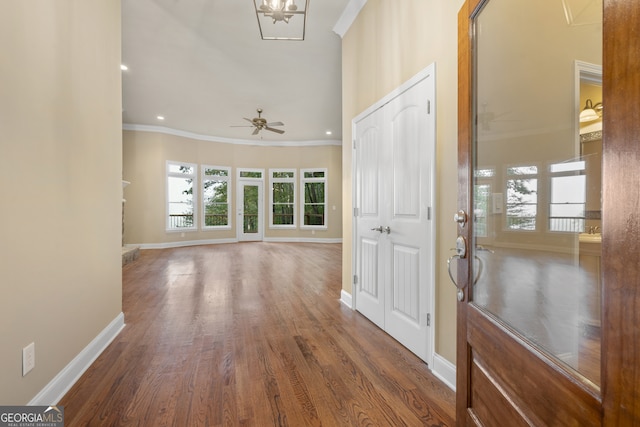 entrance foyer with dark wood-type flooring, ceiling fan, and crown molding