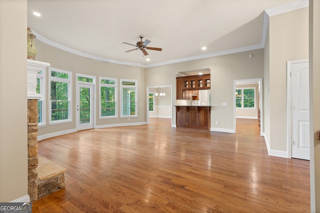 unfurnished living room featuring light wood-type flooring, ceiling fan, and crown molding