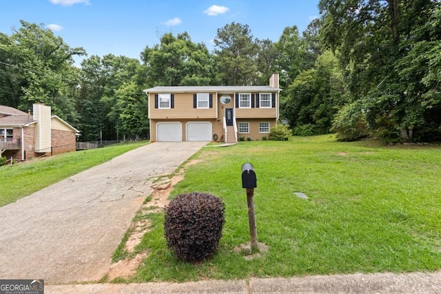 raised ranch featuring a garage and a front lawn