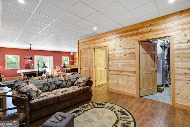 living room featuring wood-type flooring, wood walls, billiards, and a paneled ceiling