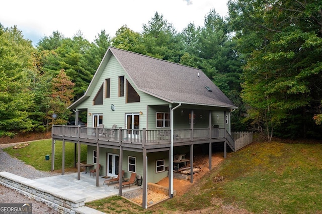 view of front of property featuring a deck, a front lawn, and a patio area