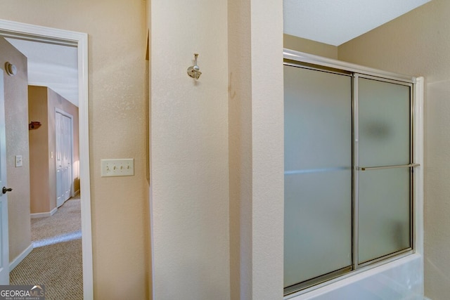 bathroom featuring shower / bath combination with glass door