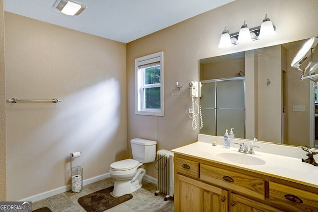 bathroom with tile patterned flooring, radiator, a shower with door, vanity, and toilet