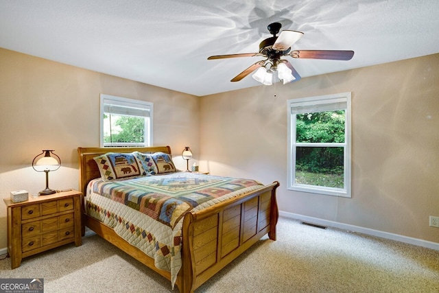 bedroom with ceiling fan and light carpet