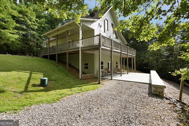 rear view of house featuring a yard, a deck, and a patio area