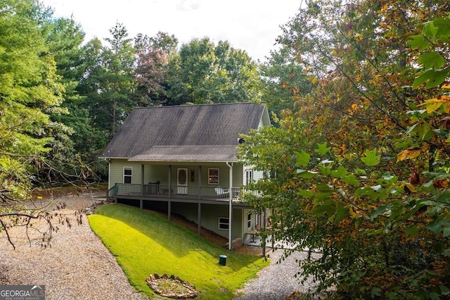 rear view of property featuring a lawn