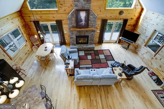 living room featuring a skylight, high vaulted ceiling, and a wealth of natural light