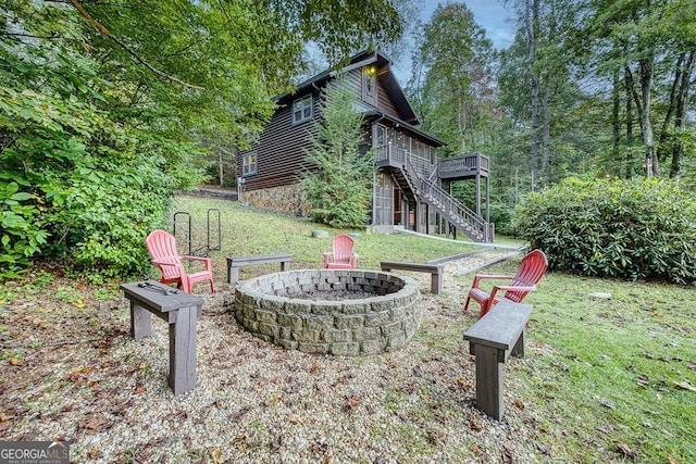 view of yard with a wooden deck and an outdoor fire pit