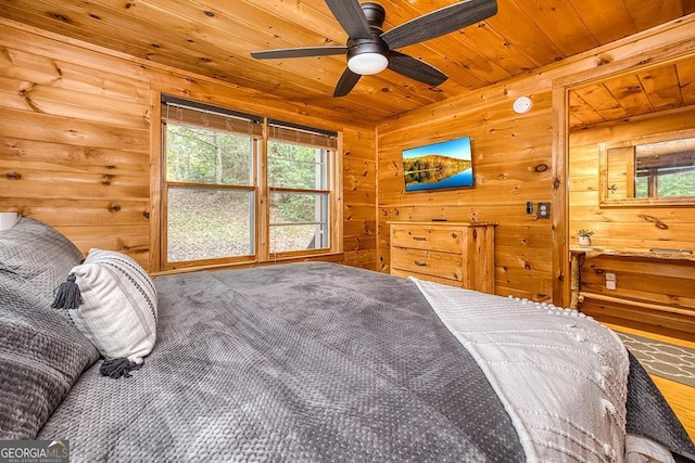 bedroom with ceiling fan, wood walls, and wooden ceiling