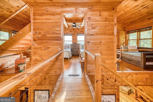 hall featuring wood-type flooring, wood ceiling, lofted ceiling, and a wealth of natural light