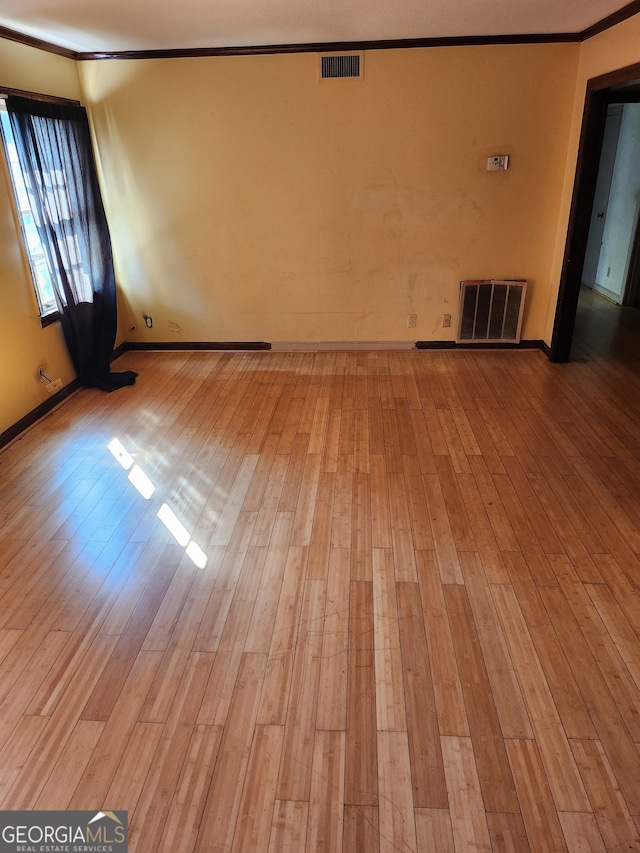 unfurnished room featuring crown molding and light hardwood / wood-style floors