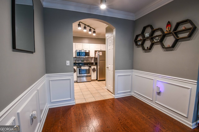 interior space featuring light wood-type flooring, crown molding, and rail lighting