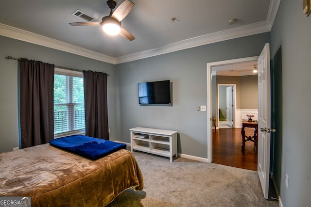 bedroom with ornamental molding, ceiling fan, and light colored carpet