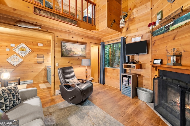 living room with wooden walls and light hardwood / wood-style flooring