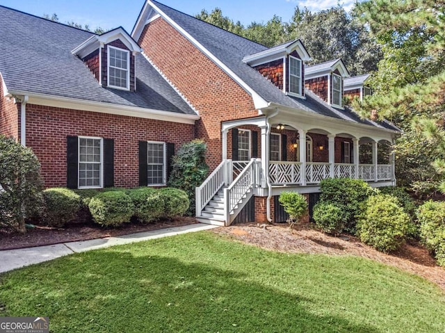 new england style home featuring a front lawn and a porch