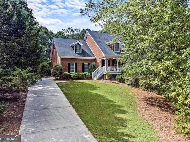 cape cod home featuring a front yard