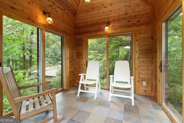 unfurnished sunroom with a wealth of natural light, vaulted ceiling, and wooden ceiling