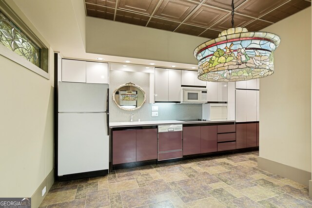 kitchen featuring white appliances, sink, and white cabinetry