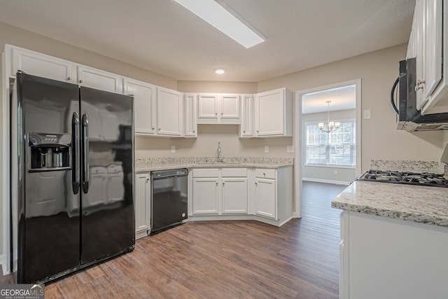 kitchen featuring light stone countertops, white cabinetry, sink, dark hardwood / wood-style flooring, and black appliances