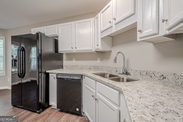 kitchen featuring white cabinetry, sink, black appliances, and light hardwood / wood-style floors