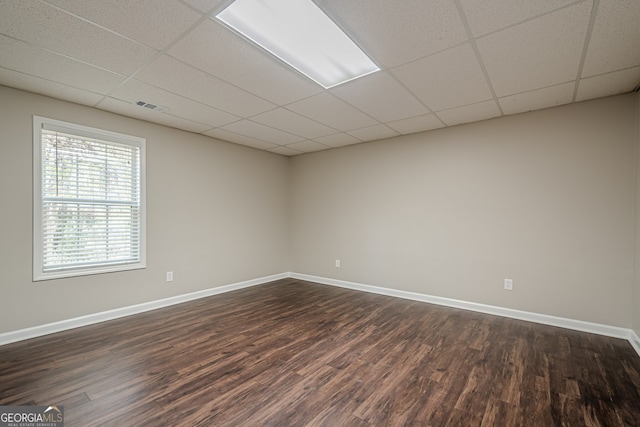 unfurnished room with a drop ceiling and dark hardwood / wood-style floors