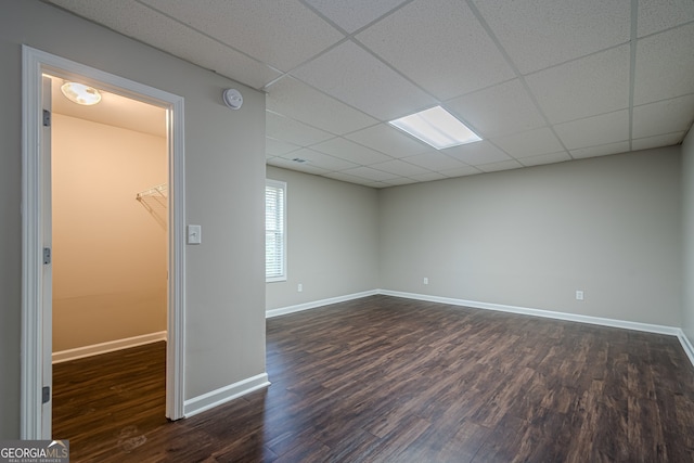 unfurnished room featuring a paneled ceiling and dark hardwood / wood-style floors