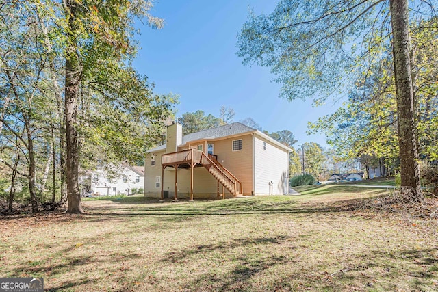 rear view of house with a lawn and a deck