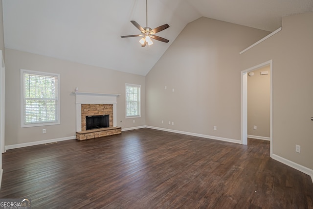 unfurnished living room featuring a stone fireplace, ceiling fan, dark hardwood / wood-style flooring, and high vaulted ceiling