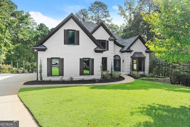 french country inspired facade featuring a front lawn