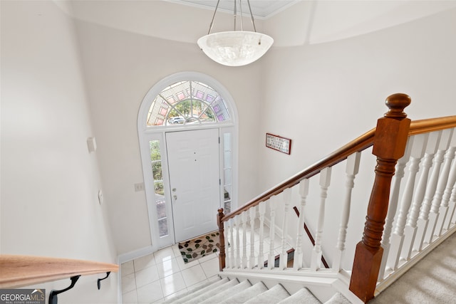 foyer entrance featuring light tile patterned floors and ornamental molding