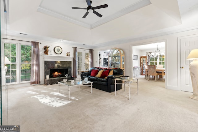 living room featuring light colored carpet, a wealth of natural light, a high end fireplace, and a raised ceiling