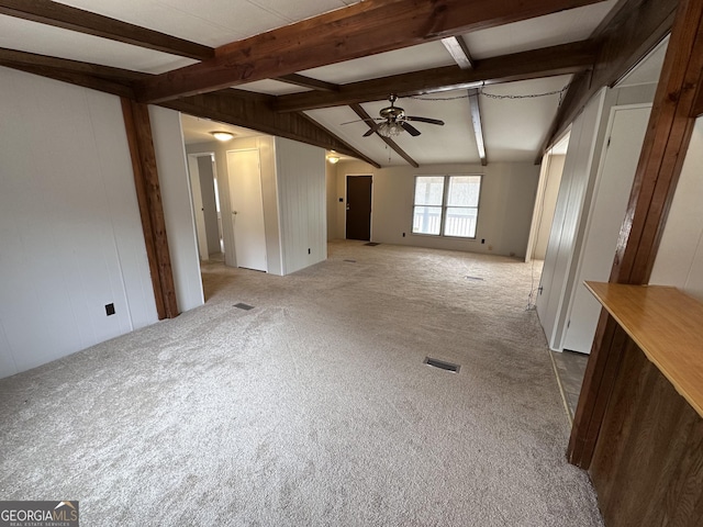 unfurnished living room with carpet flooring, vaulted ceiling with beams, and ceiling fan