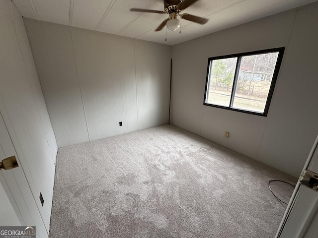 carpeted spare room featuring ceiling fan