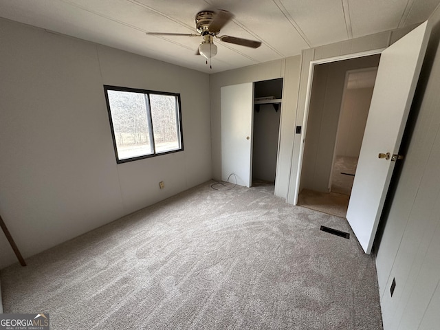 unfurnished bedroom with a closet, ceiling fan, and carpet flooring