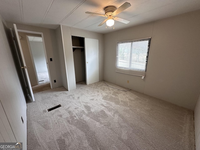 unfurnished bedroom with light carpet, a closet, and ceiling fan