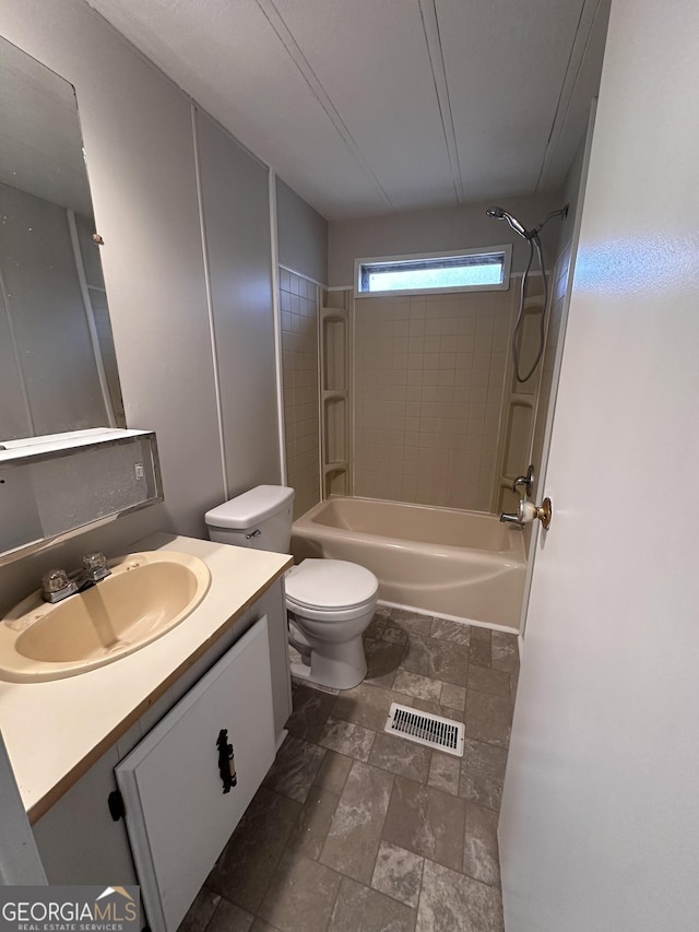 full bathroom with tiled shower / bath combo, vanity, and toilet