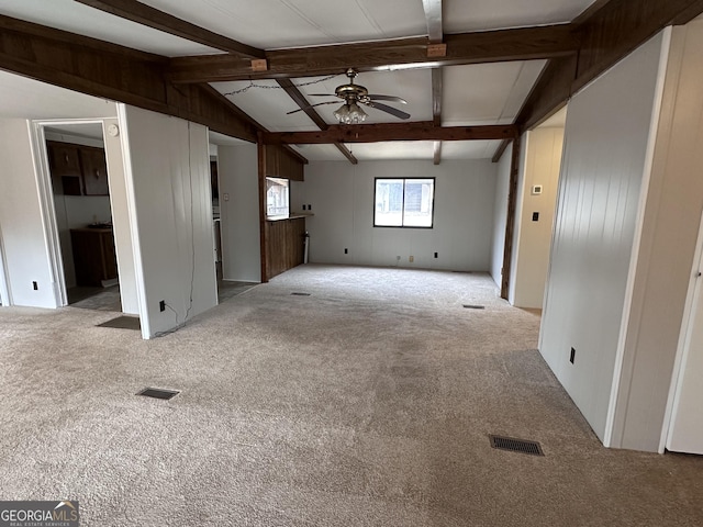 unfurnished living room with light carpet, vaulted ceiling with beams, and ceiling fan